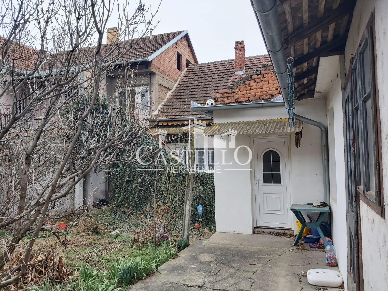 Pravo je dvorišni, donji ulaz u kuću. Ispod baštenskog stola se nalazi poklopac bazena sa vodom.  